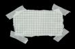 squared strip of paper with white plaster pieces