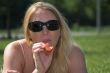 Blond woman eating a strawberry