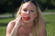 Blond woman eating a strawberry