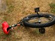A unicycle with red seat at rest