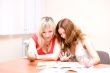 Two beautiful girls are looking through a magazine