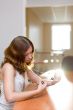 Pretty brunette in a room tuching beads