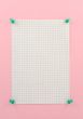 piece of squared paper pinned to pink wall