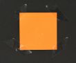 orange post-it stuck to a blackboard with tape