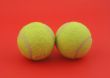 two tennis balls on red