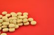 handful of yellow tablets on red