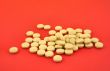 handful of yellow tablets on red