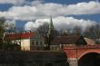 Church, houses, and bridge in sunny day with clouds