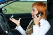 Red-haired woman with mobile-phone in a car