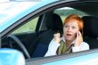 Red-haired woman with mobile-phone in a car