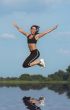 woman jumping above water