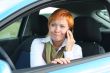 Red-haired woman with mobile-phone in a car