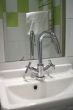 Green tiles, shiny faucet.