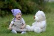 baby on the grass with a bear toy