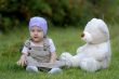 baby on the grass with a bear toy