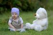 baby on the grass with a bear toy