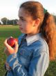 Girl with an apple on a feild