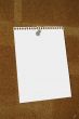 blank paper sheet thumbtacked to cork board