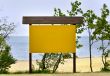 empty noticeboard, sea in background
