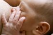 close up of newborn baby near breast