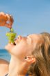 close up of girl eating grapes
