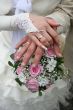 Female and male newlyweds hands with bouquete