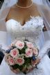 Bride torso with bouquet in white wedding dress