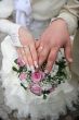 Female and male newlyweds hands with bouquete
