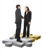 business couple shaking hands on puzzle pieces