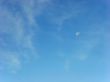 day skies with white moon and clouds