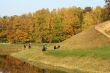 Picturesque autumn landscape of river, hill and bright trees and bushes