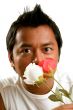 man holds 2 flowers