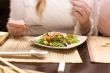 Woman eating salad in japanese restaurant