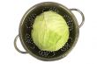 Fresh cabbage in a colander on white.