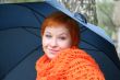 young red-haired woman in red scarf with umbrella