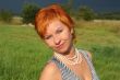 red-haired beautiful woman in dress in field