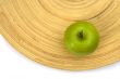 Green apple on a bamboo plate