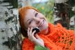 young red-haired woman in red scarf is talking in mobile-phone