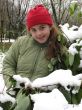 The girl in red hat near snow bush