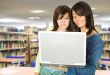 girls in the library with a laptop