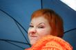 young red-haired woman in red scarf with umbrella