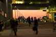 Business people comin and going with red sky