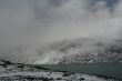 snow mountain in fog with cold lake