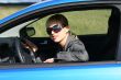 young blond woman in a blue car in sun-glasses