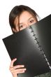 beautiful teen peeping over notebook