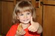Little pretty blond girl eating pancake