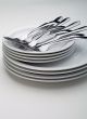 Silverware on a stack on white plates