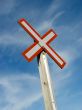 Railroad crossing sign on a blue sky background