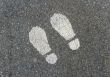 Painted footprints on asphalt