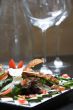 Salad with wine glasses in the background
